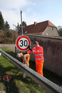 Dirk Benus und Dominik Fr&ouml;hner montieren das neue Schild.