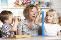 56_Bild_Erzieherin_mit_2Kindern_im_Kiga