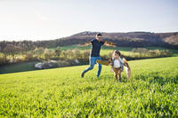 Happy toddler boy playing outside with father in spring nature