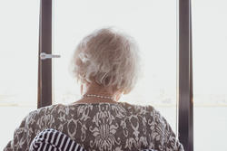 Seniorin im Rollstuhl am Fenster