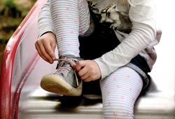 M�dchen auf einer Rutsche bindet die Schn�rsenckel