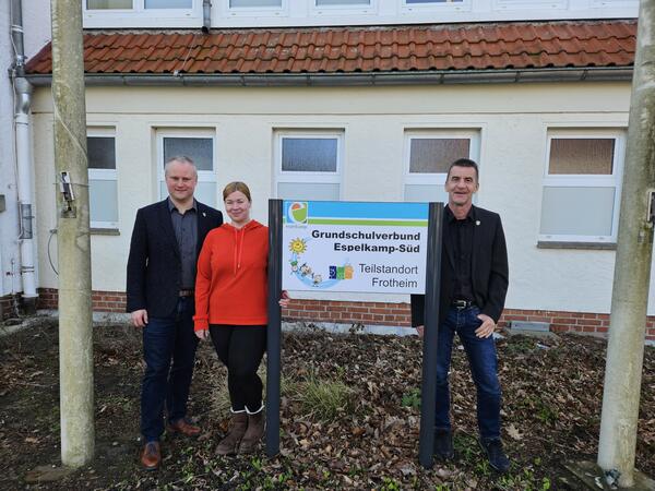B�rgermeister Dr. Henning Vieker, Schulsozialarbeiterin Jasmin Rohr und Schulamtsleiter Andreas Bredenk�tter vor dem Grundschulschild in Frotheim (v.l.)