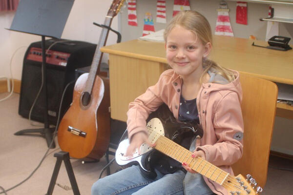 Freda probiert die E-Gitarre aus