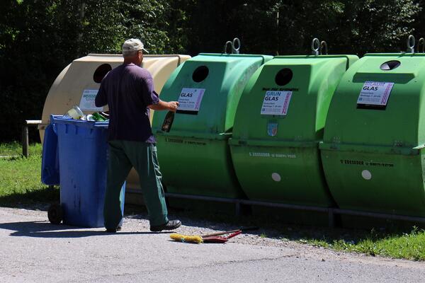 Mann vor Altglascontainern