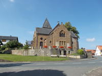 Evangelische Kirche Bad Holzhausen: historischer Sandsteinbau mit Spitzdach und roten Blumenk�sten an der Br�stung.