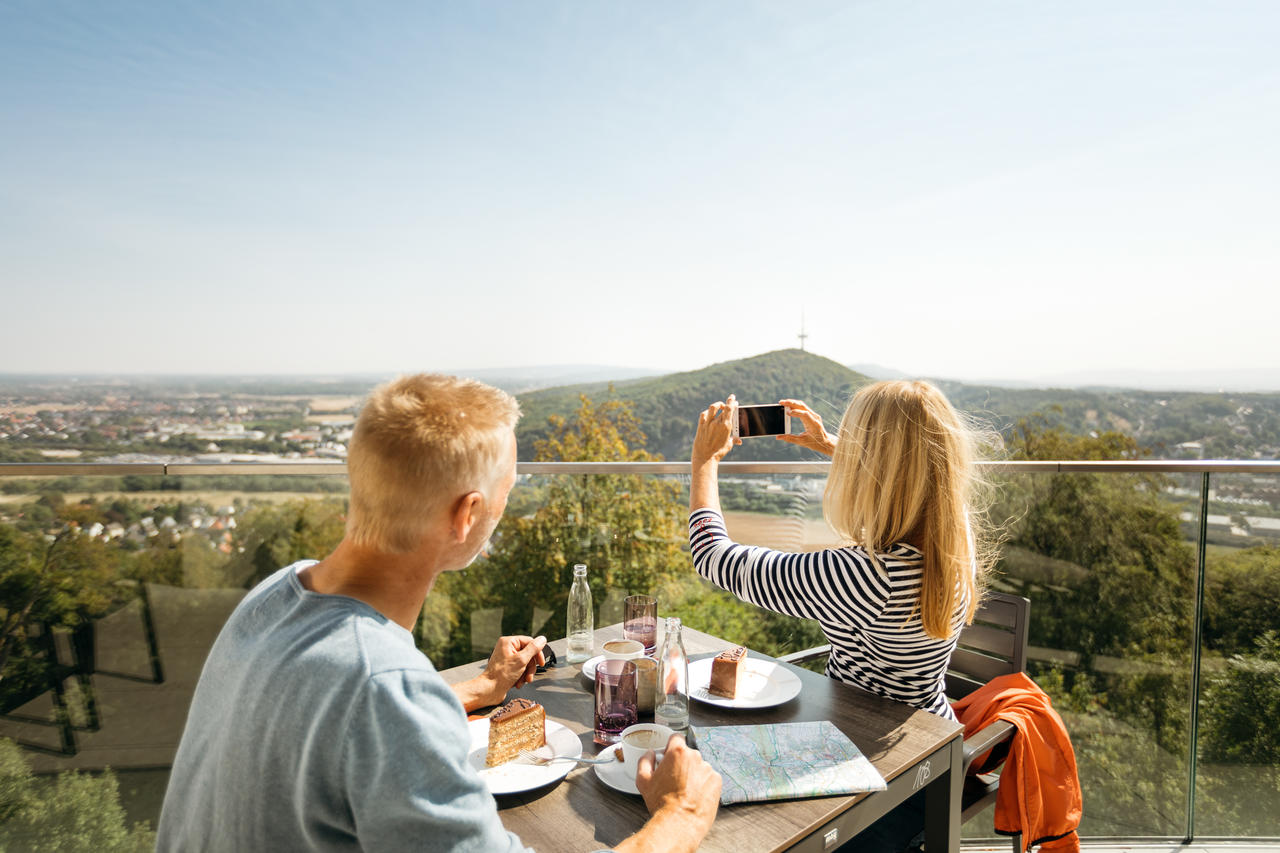 Zwei Personen sitzen an einem Tisch, essen und genie�en den Ausblick �ber die Landschaft