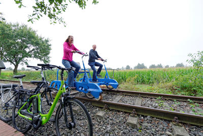 Zwei Personen fahren auf einer Draisine