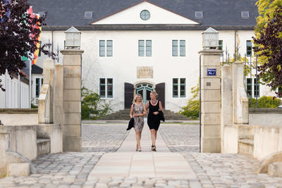 Zwei Damen gehen am Schloss Benkhausen spazieren